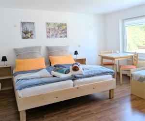 a bedroom with a bed with a stuffed animal on it at Ferienwohnung Gartenblick in Fuhlendorf