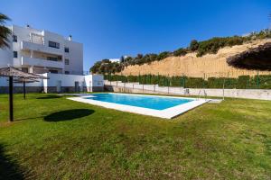 a swimming pool in a yard next to a building at Casa Frank in Conil de la Frontera