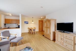 a living room with a large flat screen tv at Fewo Brünnstein - Nr 28 Pool, Sauna in Oberaudorf +9 photos
