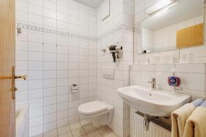 a white bathroom with a toilet and a sink at Fewo Brünnstein - Nr 28 Pool, Sauna in Oberaudorf