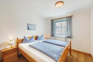 a bedroom with a bed with blue and white pillows at Fewo Brünnstein - Nr 28 Pool, Sauna in Oberaudorf