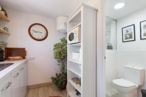 a bathroom with a toilet and a clock on the wall at Finca la Florida in Icod de los Vinos +25 photos