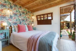 a bedroom with a bed with pink pillows at Finca la Florida in Icod de los Vinos