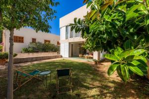 a yard with two chairs and a building at Villa Mercedes in Artá