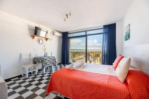 a bedroom with a bed and a view of the ocean at Estudio Mirada 304 in Es Pujols