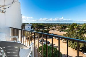 a balcony with white chairs and a view of a parking lot at Estudio Mirada 304 in Es Pujols