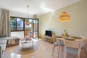 a living room with a table and a dining room at Oasis Duna-Pistacho dreams Pool in Corralejo