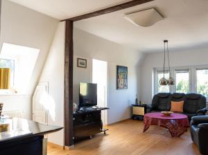 a living room with a couch and a tv at Apartment in Villa Rochlitz in Rochlitz
