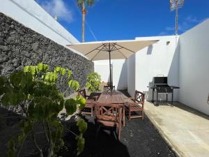 a patio with a table and umbrella and a piano at Casa Guayo in Tías