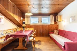 a dining room with a table and a couch at Unterhauserhof App C in Valdaora