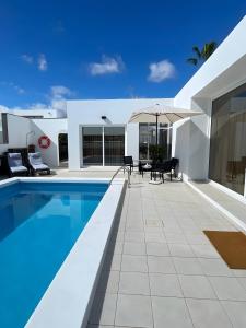 a house with a swimming pool and a patio at Casa Guayo in Tías