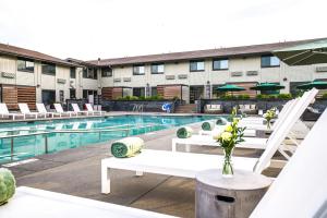 a hotel pool with white tables and chairs and a building at Ruby River Hotel in Spokane