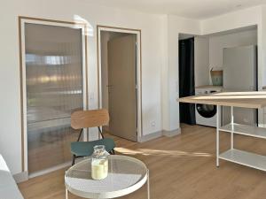 a living room with a table and a chair at Au p'tit Colombier in Hillion +2 photos