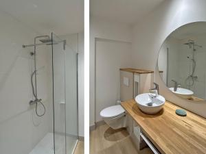 a bathroom with a sink and a toilet and a mirror at Au p'tit Colombier in Hillion
