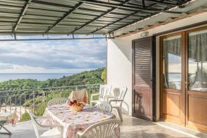 a patio with a table and chairs and a view of the ocean at Simona Panorama in Fetovaia