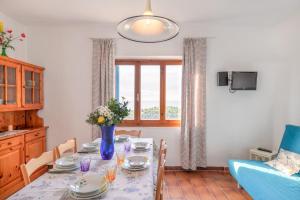 a dining room table with a vase of flowers on it at Simona Panorama in Fetovaia