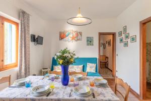 a dining room table with a vase of flowers on it at Simona Panorama in Fetovaia