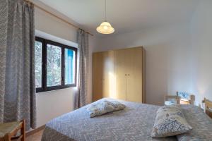 a bedroom with a bed and a large window at Simona Panorama in Fetovaia
