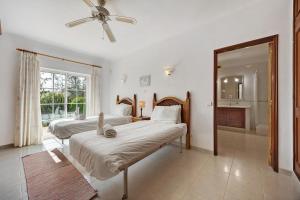 a bedroom with two beds and a ceiling fan at Monte Lemos Villa 35 in Luz +22 photos