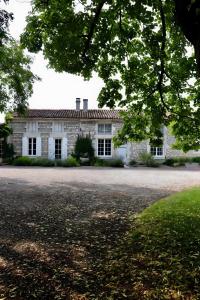 an old stone house with a driveway in front of it at Gite La Saintonge in Sainte-Gemme