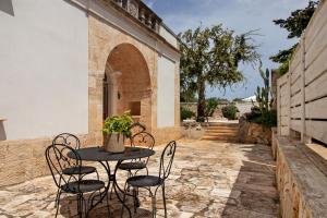 a patio with a table and chairs on a stone courtyard at La Dimora dello Zio, with pool in Ostuni