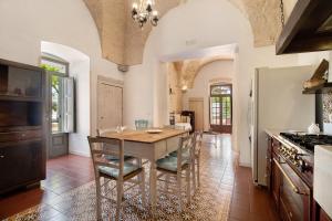 a kitchen with a table and chairs and a stove at La Dimora dello Zio, with pool in Ostuni