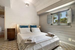 a bedroom with a large white bed with a window at La Dimora dello Zio, with pool in Ostuni +28 photos