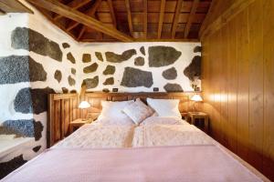 a bedroom with a bed in a stone wall at Casa el Gordi in El Paso