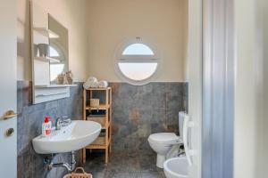 a bathroom with a sink and a toilet and a window at Casa Moki in Uliveto Terme +14 photos