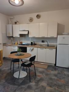a kitchen with white cabinets and a table and chairs at Casa Moki in Uliveto Terme