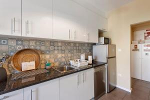 a kitchen with white cabinets and a sink and a refrigerator at Destiny Oporto in Maia