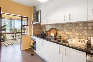 a kitchen with white cabinets and a sink at Destiny Oporto in Maia