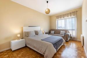 a bedroom with a large bed and a couch at Destiny Oporto in Maia +19 photos