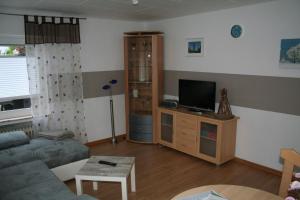 a living room with a couch and a tv at Ferienwohnung Sammet in Brilon