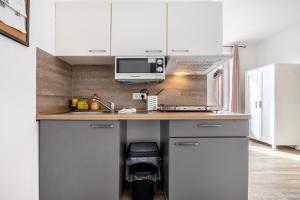 a kitchen with white cabinets and a counter top at Himmelpforten Loft in Himmelpforten