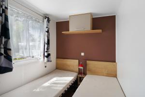 a small bedroom with a bed and a window at Mobilehome 5 personnes in Les Mathes