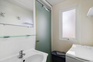 a bathroom with a sink and a mirror at Mobilehome 5 personnes in Les Mathes +16 photos
