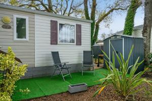 a yard with two chairs and a house at Mobilehome 5 personnes in Les Mathes