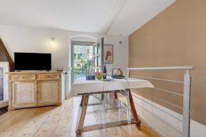 a living room with a table and a television at La Guardiola I By Immobilux in Riva del Garda