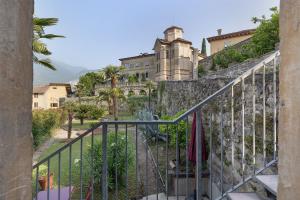 a castle on top of a stone wall with a staircase at La Guardiola I By Immobilux in Riva del Garda