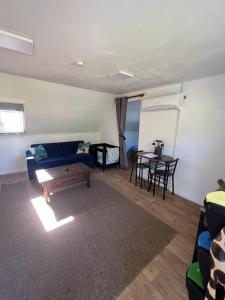 a living room with a blue couch and a table at Maple Tree Chambre d'hôtes in Darnac