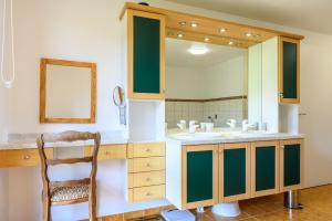 a bathroom with a sink and a mirror and a chair at Gîte La Ramée in Ban-sur-Meurthe-Clefcy +25 photos