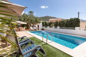 a swimming pool with a chair next to a house at Primera Planta in Cartagena