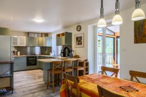 a kitchen with a table and a dining room at Gîte La Ramée in Ban-sur-Meurthe-Clefcy