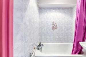 a bathroom with a white tub and a pink shower curtain at Chalet de l'Ardoisière in Saint-Colomban-des-Villards +100 photos