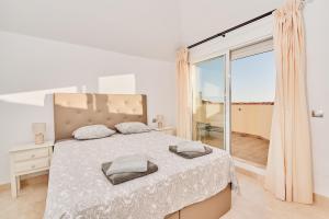 a white bedroom with a bed and a large window at Beautiful Penthouse in Torrox Costa +23 photos