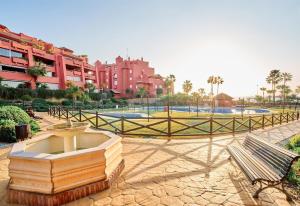 a park with a fountain and a bench and buildings at Beautiful Penthouse in Torrox Costa