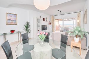 a dining room and living room with a glass table and chairs at Beautiful Penthouse in Torrox Costa