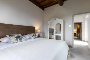 a bedroom with a large white bed and a mirror at Villa Arnolfo in Colle di Val d'Elsa +123 photos
