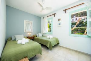 a bedroom with two beds and a window at Can Botana 9 in Cala de Sant Vicenc +18 photos